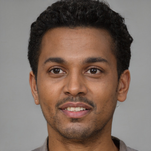 Joyful latino young-adult male with short  brown hair and brown eyes