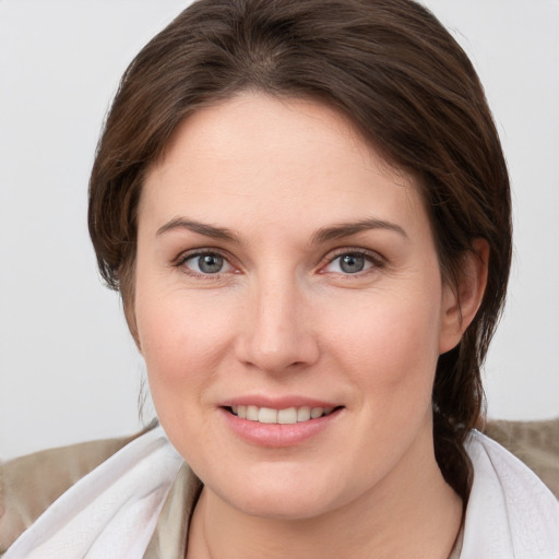 Joyful white young-adult female with medium  brown hair and grey eyes