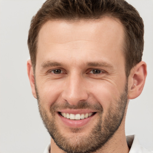 Joyful white young-adult male with short  brown hair and brown eyes