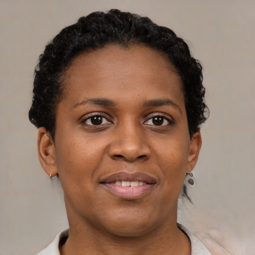 Joyful black young-adult female with short  brown hair and brown eyes