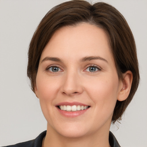 Joyful white young-adult female with medium  brown hair and grey eyes