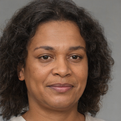 Joyful black adult female with medium  brown hair and brown eyes