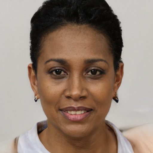 Joyful black young-adult female with short  black hair and brown eyes