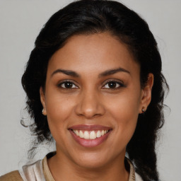 Joyful black young-adult female with medium  brown hair and brown eyes