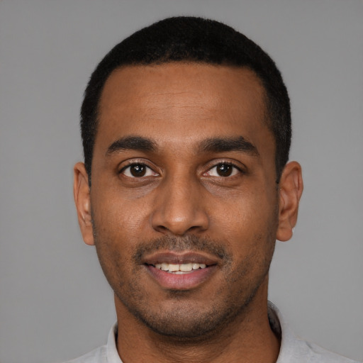 Joyful black young-adult male with short  black hair and brown eyes