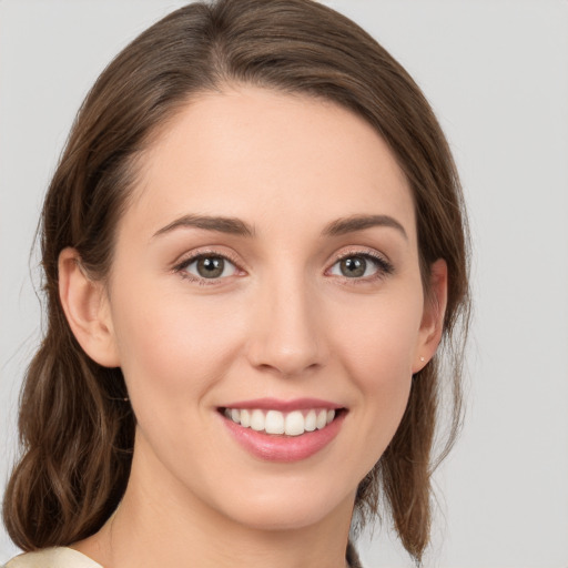 Joyful white young-adult female with medium  brown hair and grey eyes