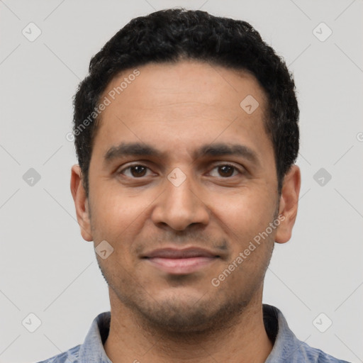 Joyful latino young-adult male with short  black hair and brown eyes