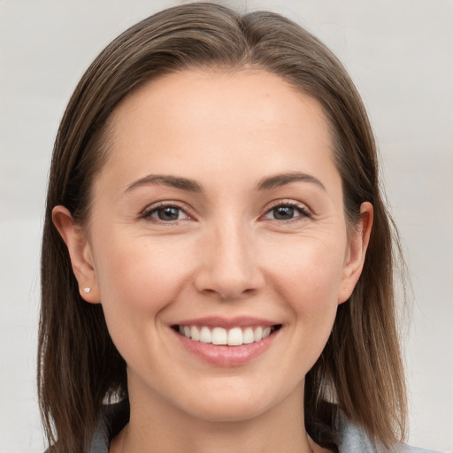 Joyful white young-adult female with long  brown hair and grey eyes