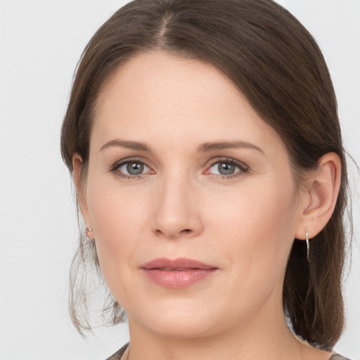 Joyful white young-adult female with medium  brown hair and grey eyes