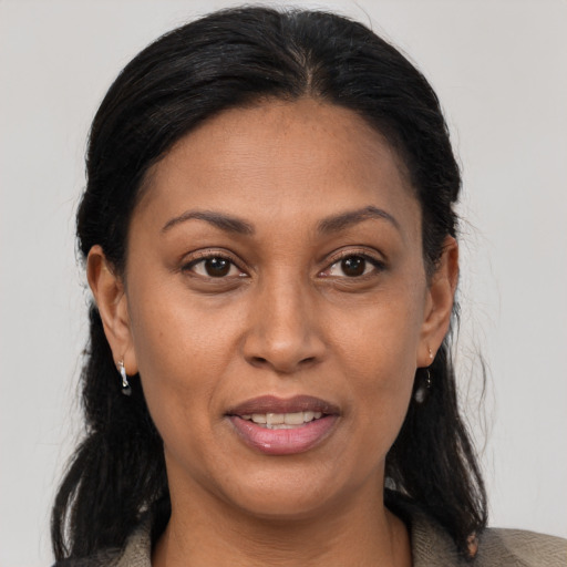 Joyful latino adult female with medium  brown hair and brown eyes