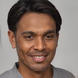 Joyful black young-adult male with short  brown hair and brown eyes