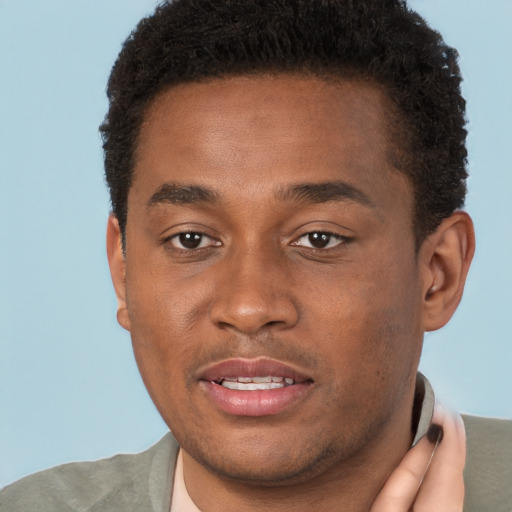 Joyful black young-adult male with short  brown hair and brown eyes