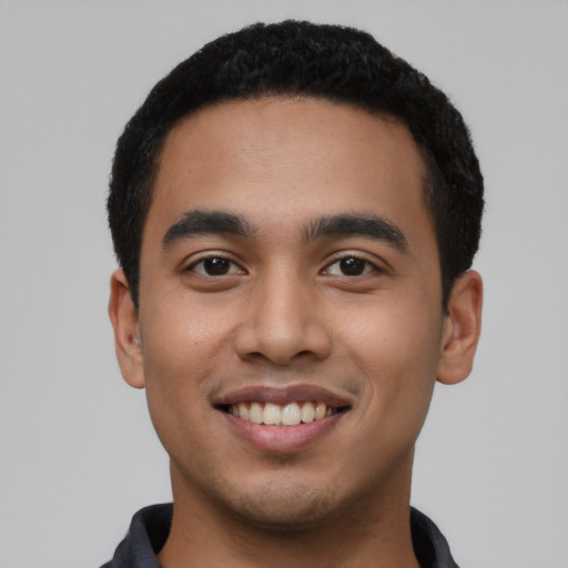 Joyful latino young-adult male with short  black hair and brown eyes