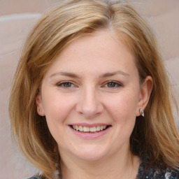 Joyful white young-adult female with medium  brown hair and blue eyes