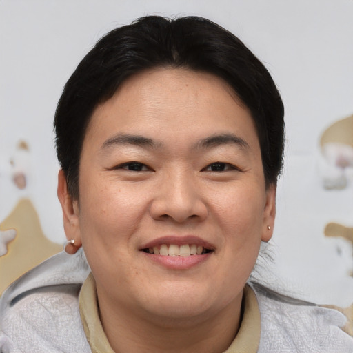 Joyful asian young-adult female with short  brown hair and brown eyes