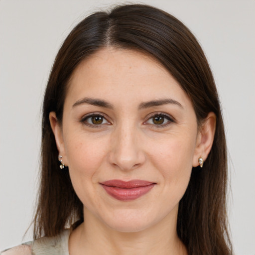 Joyful white young-adult female with long  brown hair and brown eyes