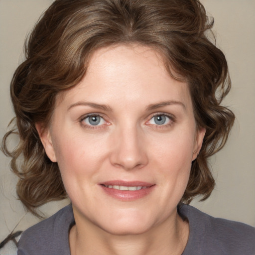 Joyful white young-adult female with medium  brown hair and blue eyes