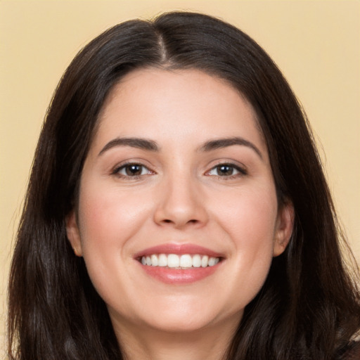 Joyful white young-adult female with long  brown hair and brown eyes