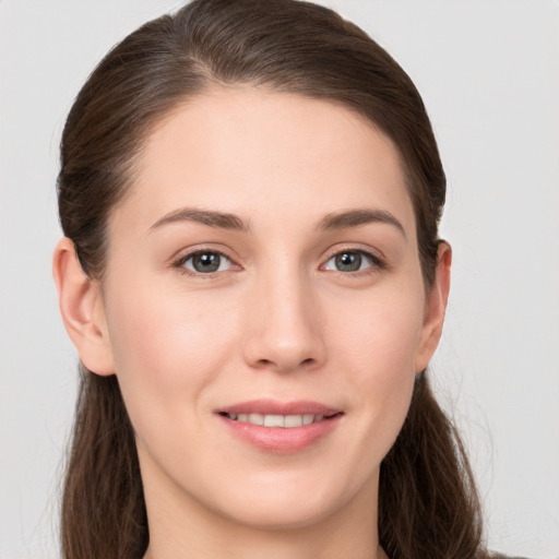 Joyful white young-adult female with long  brown hair and grey eyes