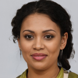 Joyful latino adult female with medium  brown hair and brown eyes