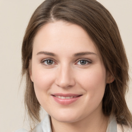 Joyful white young-adult female with medium  brown hair and grey eyes