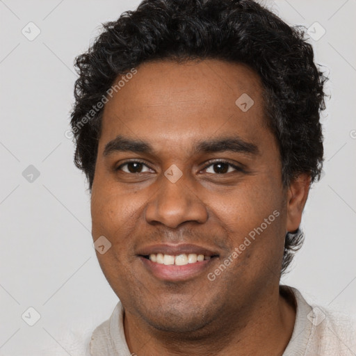 Joyful black young-adult male with short  brown hair and brown eyes