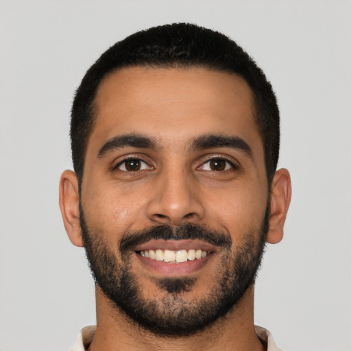 Joyful latino young-adult male with short  black hair and brown eyes