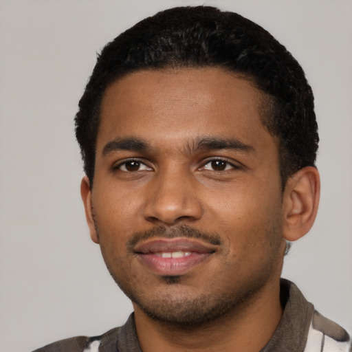 Joyful black young-adult male with short  black hair and brown eyes