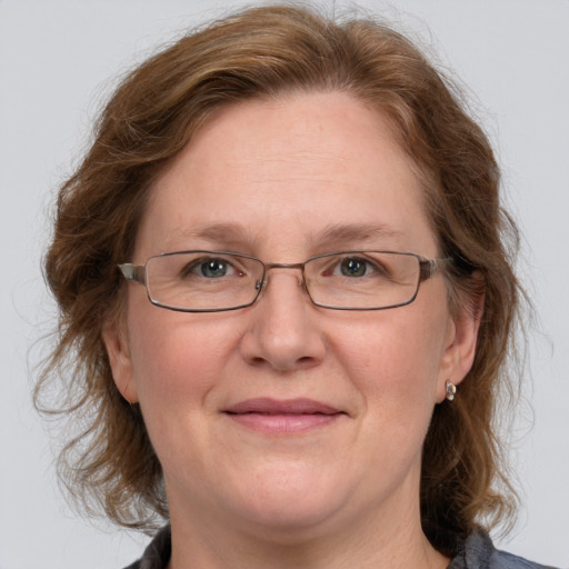 Joyful white adult female with medium  brown hair and blue eyes