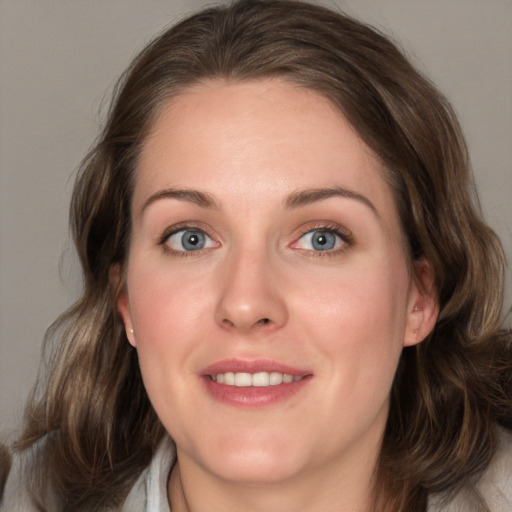 Joyful white young-adult female with medium  brown hair and blue eyes