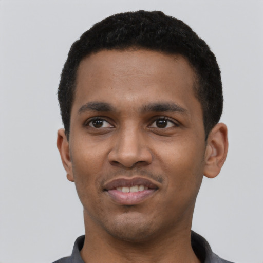 Joyful black young-adult male with short  black hair and brown eyes