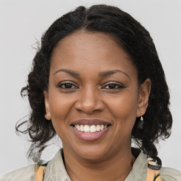 Joyful black adult female with medium  brown hair and brown eyes