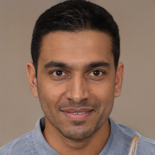 Joyful latino young-adult male with short  black hair and brown eyes