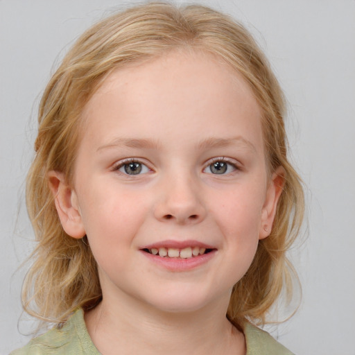 Joyful white child female with medium  blond hair and blue eyes