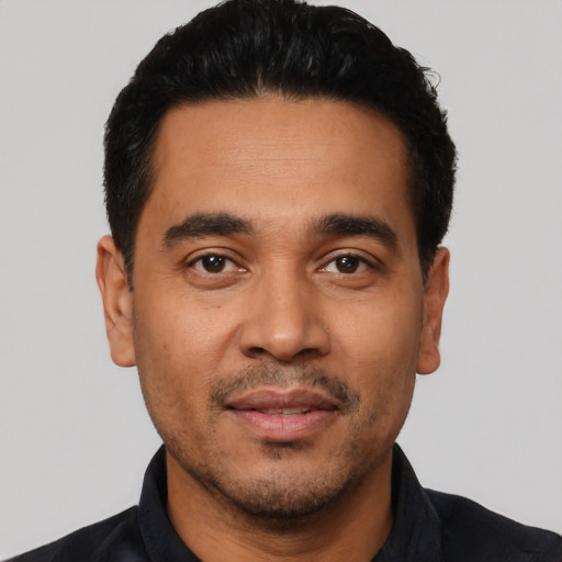 Joyful latino young-adult male with short  black hair and brown eyes