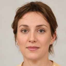 Joyful white young-adult female with medium  brown hair and green eyes