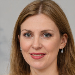 Joyful white adult female with long  brown hair and grey eyes