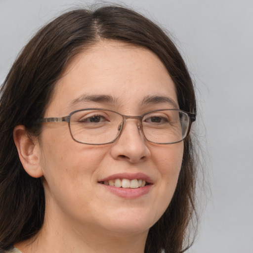 Joyful white adult female with long  brown hair and brown eyes