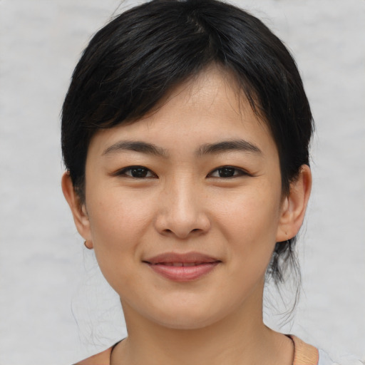 Joyful asian young-adult female with medium  black hair and brown eyes