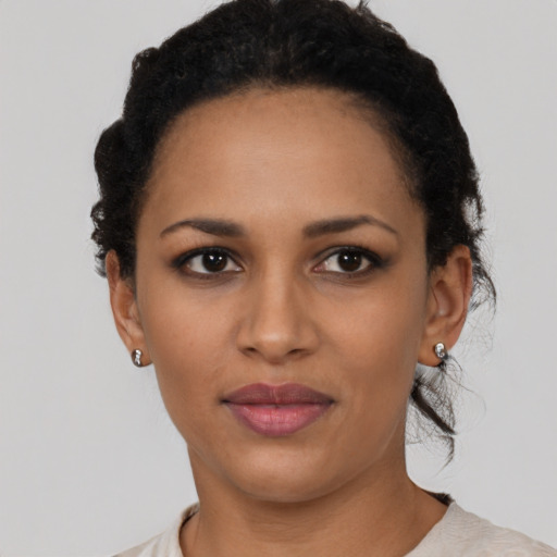 Joyful black young-adult female with short  black hair and brown eyes