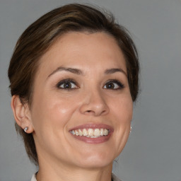 Joyful white adult female with medium  brown hair and brown eyes