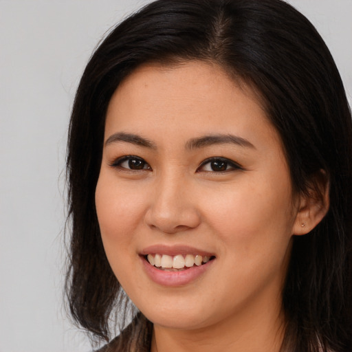 Joyful asian young-adult female with long  brown hair and brown eyes