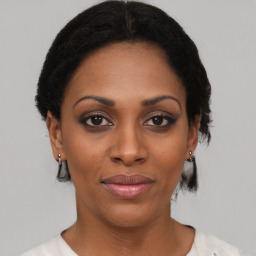 Joyful black young-adult female with short  black hair and brown eyes