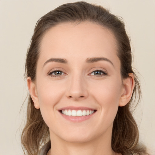 Joyful white young-adult female with long  brown hair and green eyes