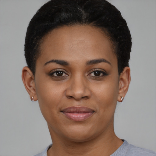Joyful black young-adult female with short  black hair and brown eyes