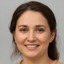 Joyful white adult female with medium  brown hair and brown eyes