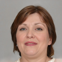 Joyful white adult female with medium  brown hair and blue eyes