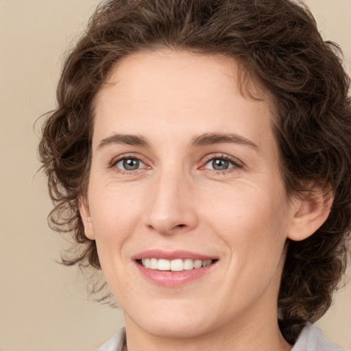 Joyful white young-adult female with medium  brown hair and green eyes