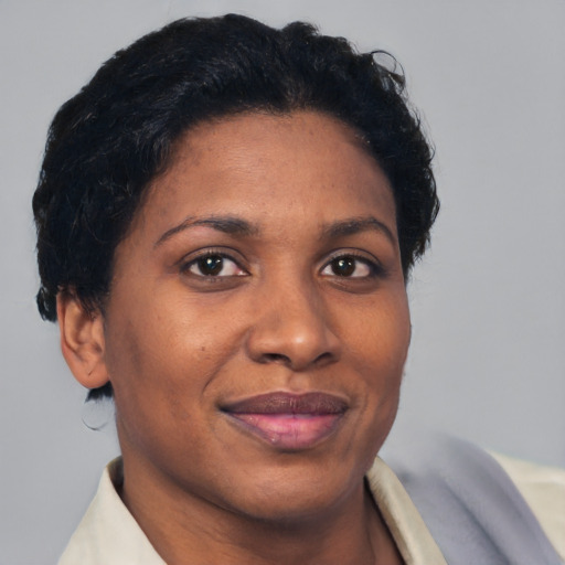 Joyful black adult female with short  brown hair and brown eyes