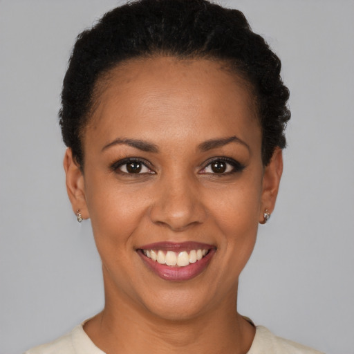 Joyful black young-adult female with short  black hair and brown eyes